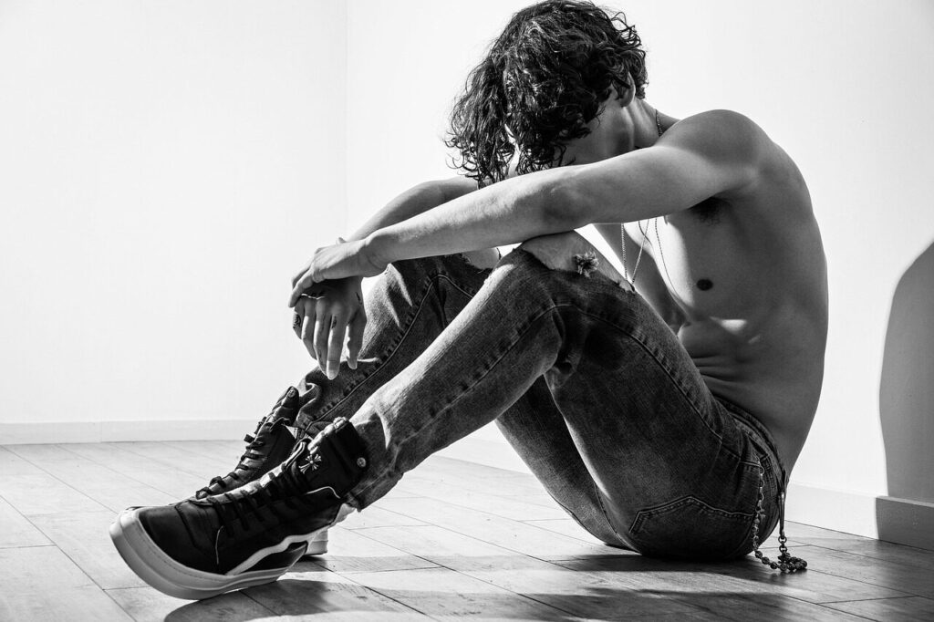 man struggling alone, person sitting in darkness because of habitual sins_ Word Anchored
